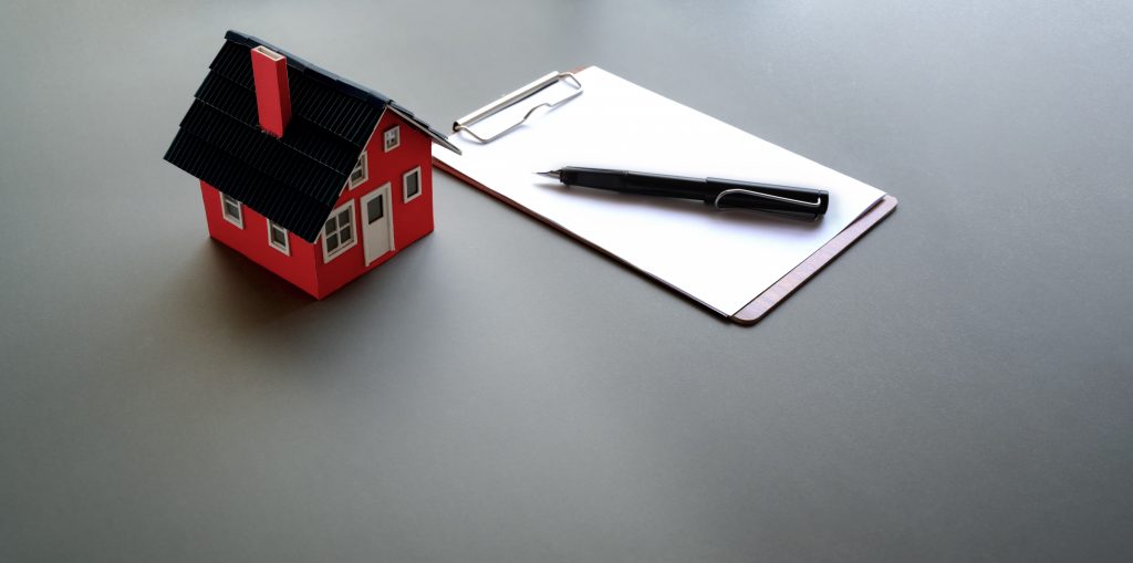 макет на къща, документ и химикалка