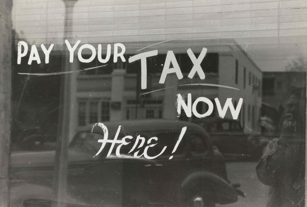 надпис "Плати данъка/таксита си сега тук", изписан върху стъкло